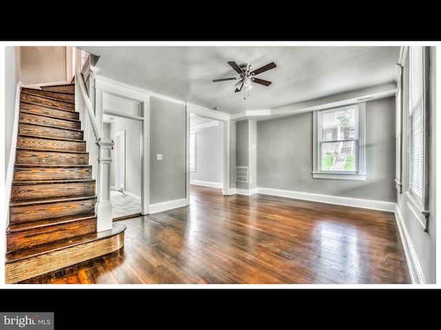 unfurnished living room with baseboards, stairs, ceiling fan, and wood-type flooring