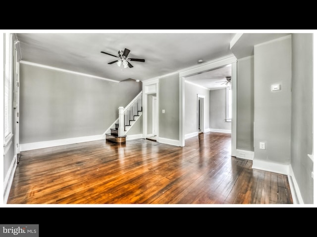 interior space featuring crown molding, baseboards, ceiling fan, stairway, and hardwood / wood-style floors