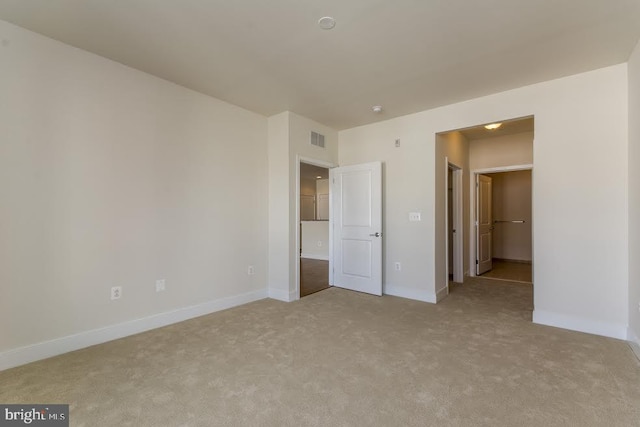 unfurnished bedroom with visible vents, baseboards, and light carpet