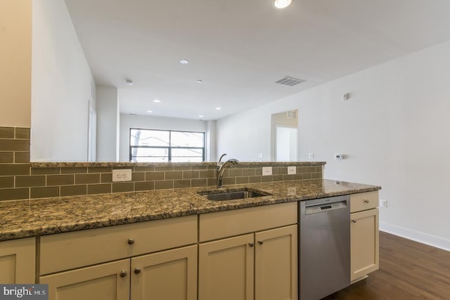 kitchen with dark stone countertops, visible vents, a sink, stainless steel dishwasher, and tasteful backsplash