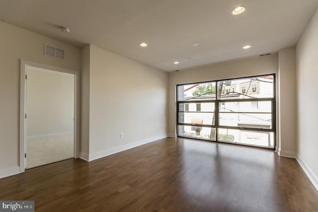 empty room with recessed lighting, visible vents, baseboards, and dark wood-style flooring