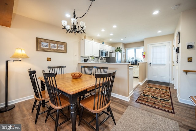 dining space with a notable chandelier, recessed lighting, and dark wood-style floors