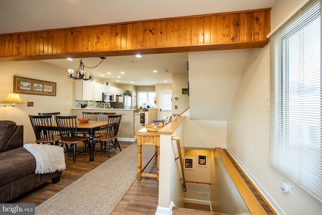 interior space featuring recessed lighting, baseboards, a notable chandelier, and wood finished floors