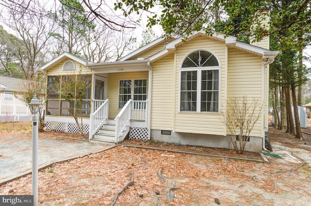 view of front of property with a chimney, a sunroom, and crawl space