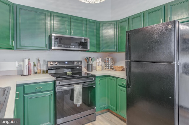 kitchen with stainless steel appliances, green cabinets, and light countertops