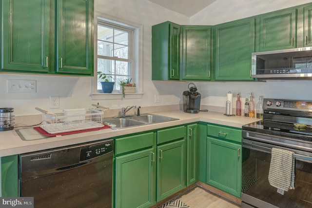 kitchen featuring green cabinets, light countertops, appliances with stainless steel finishes, and a sink