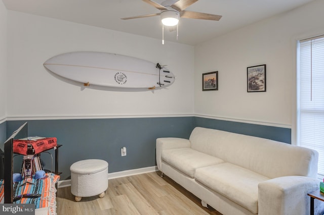 sitting room featuring baseboards, light wood-type flooring, and ceiling fan