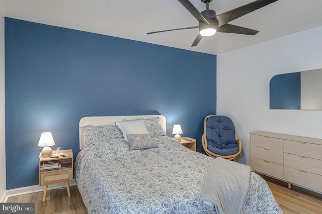 bedroom featuring baseboards, a ceiling fan, and wood finished floors