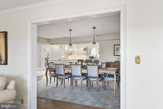 dining space with baseboards, dark wood-style flooring, and ornamental molding