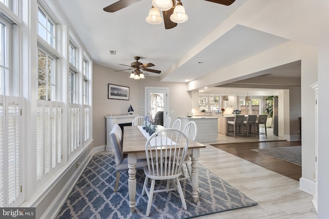 dining space featuring baseboards, wood finished floors, and a ceiling fan