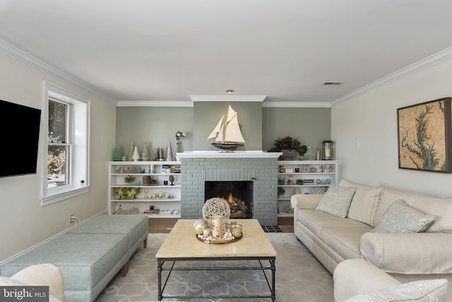 living room with visible vents, a fireplace, crown molding, and wood finished floors