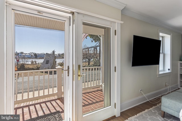 entryway featuring baseboards, wood finished floors, and crown molding