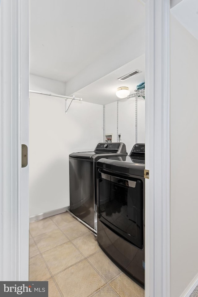 laundry room with washer and clothes dryer, visible vents, laundry area, and baseboards