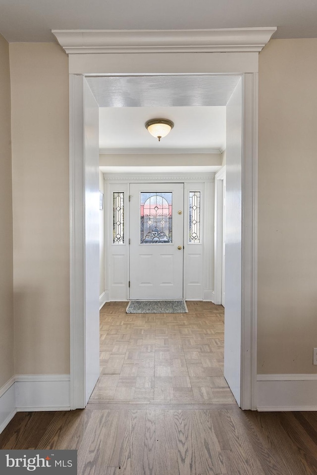 foyer entrance with baseboards and wood finished floors