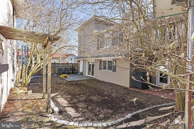 rear view of house with a patio and fence