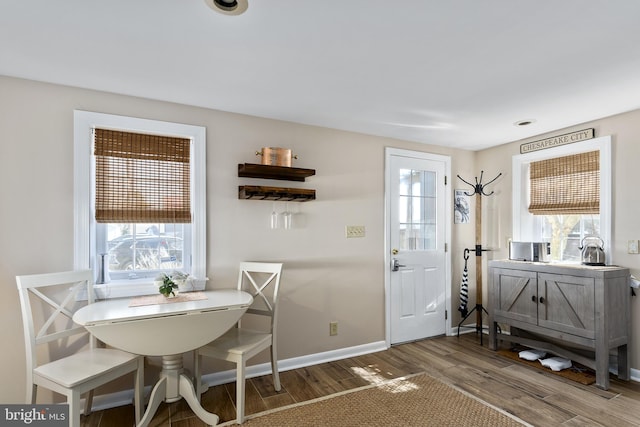 dining area featuring a healthy amount of sunlight, baseboards, and wood finished floors