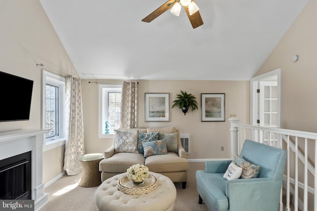 living room featuring lofted ceiling, carpet, a fireplace, baseboards, and ceiling fan