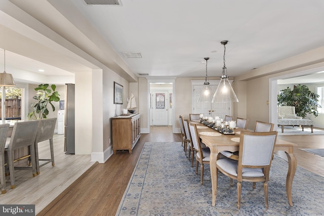 dining area featuring visible vents, wood finished floors, baseboards, and a wealth of natural light