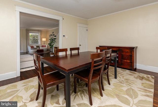 dining area featuring baseboards, light wood-type flooring, and ornamental molding