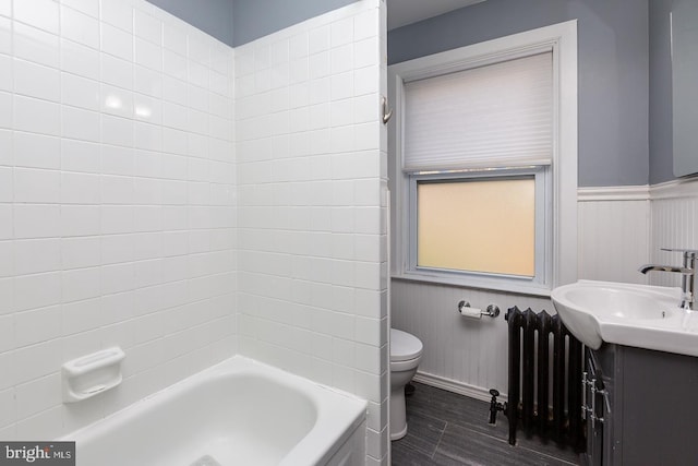 bathroom with a wainscoted wall, toilet, radiator heating unit, wood finished floors, and vanity