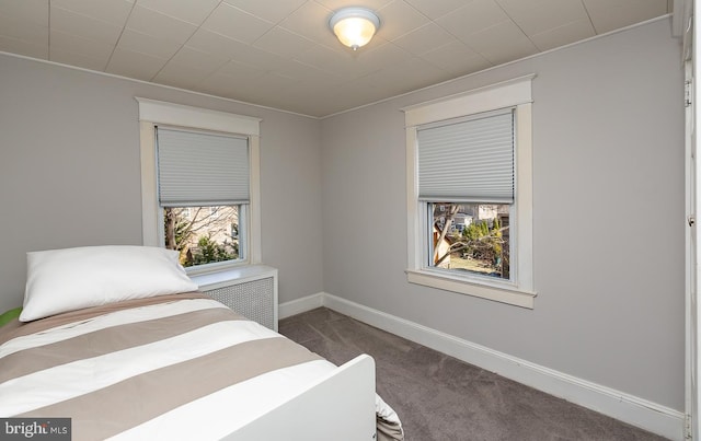 carpeted bedroom with radiator and baseboards