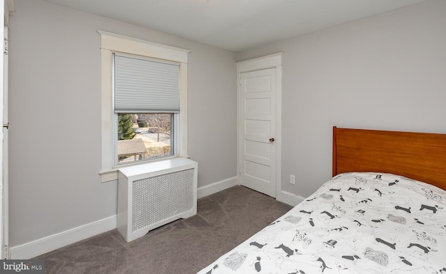 bedroom with radiator heating unit, baseboards, and dark colored carpet