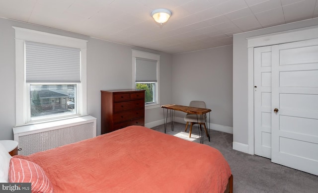 bedroom featuring carpet flooring, radiator heating unit, and baseboards