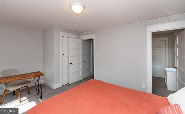 bedroom featuring a closet, baseboards, and carpet