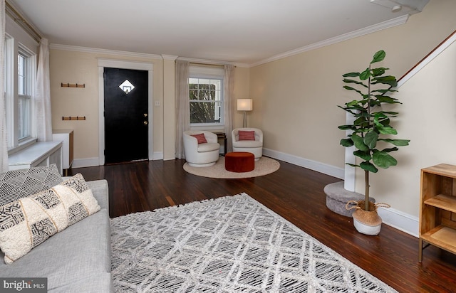 living area featuring baseboards, wood finished floors, and ornamental molding