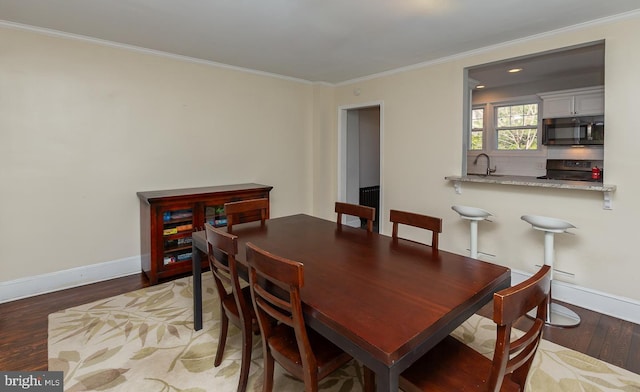 dining room with light wood-style flooring, baseboards, and ornamental molding