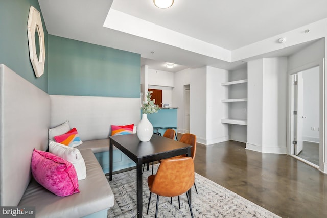 living room featuring concrete flooring and baseboards