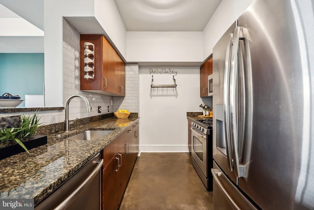 kitchen featuring baseboards, dark stone counters, decorative backsplash, stainless steel appliances, and a sink