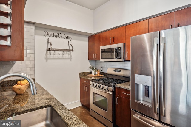 kitchen featuring decorative backsplash, dark stone countertops, stainless steel appliances, and a sink