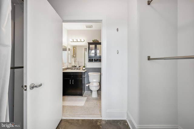 bathroom with vanity, toilet, visible vents, and concrete flooring