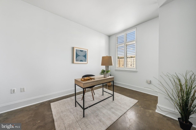 office space with finished concrete flooring and baseboards