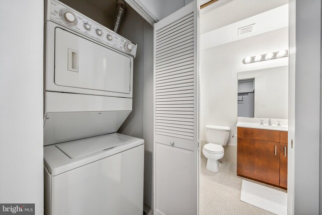 laundry room featuring stacked washer / dryer, laundry area, visible vents, and a sink