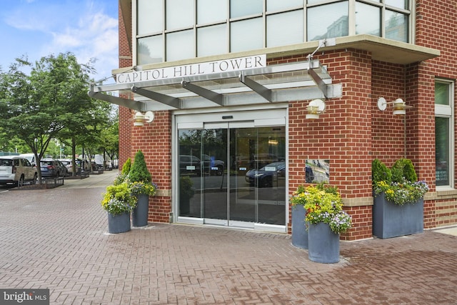 view of exterior entry featuring brick siding