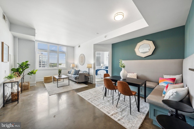 living room featuring concrete floors and baseboards