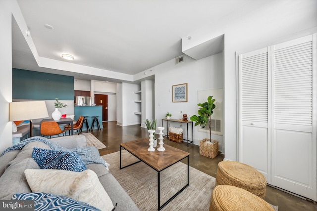 living room with finished concrete flooring and visible vents