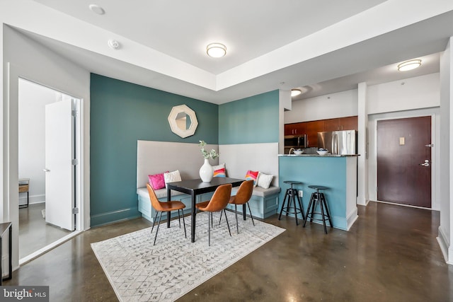 dining area with finished concrete flooring and baseboards