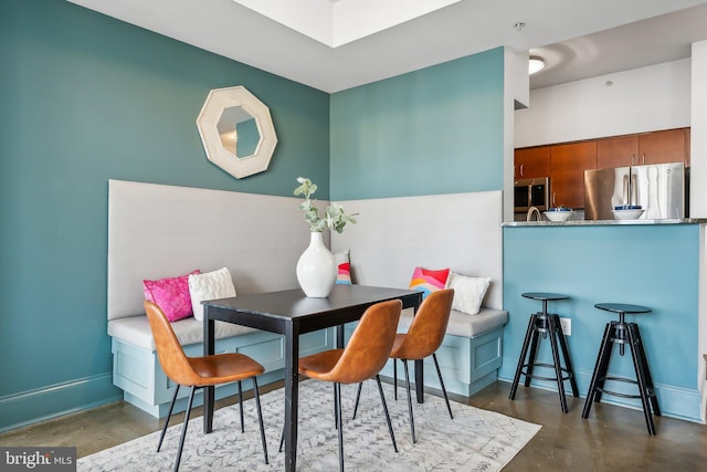 dining space with concrete floors and baseboards