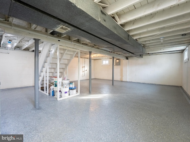 basement with stairway, electric panel, and visible vents