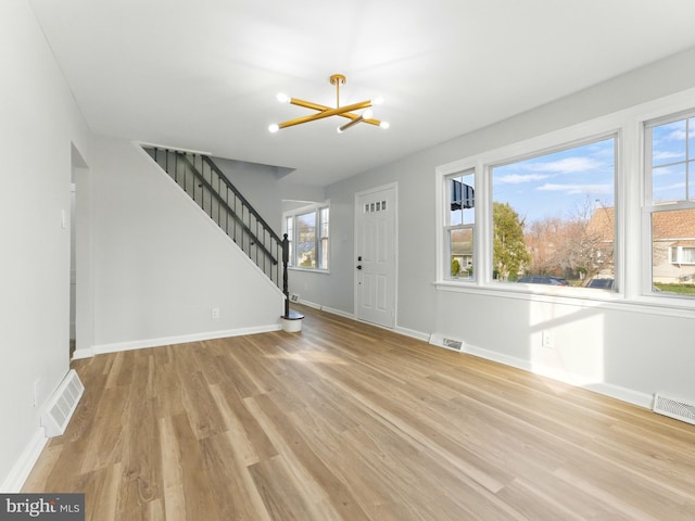 entryway featuring stairway, light wood-style floors, visible vents, and baseboards