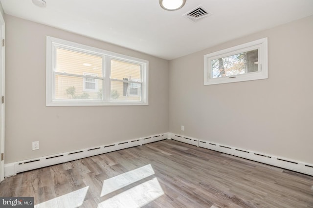 spare room with wood finished floors and visible vents