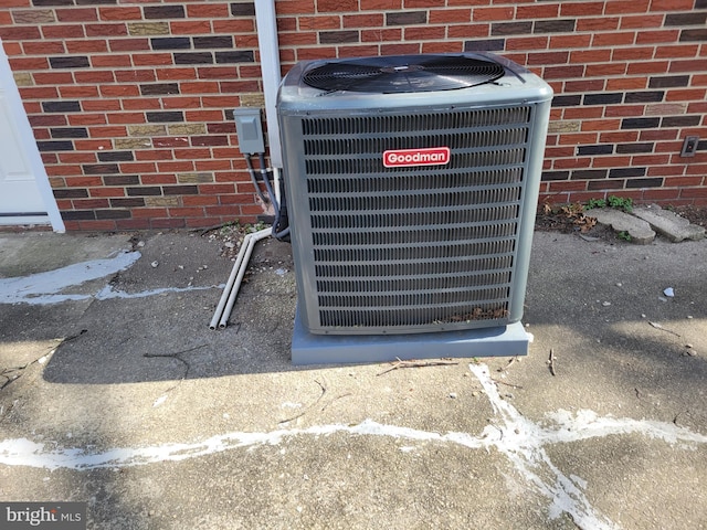 exterior details featuring cooling unit and brick siding