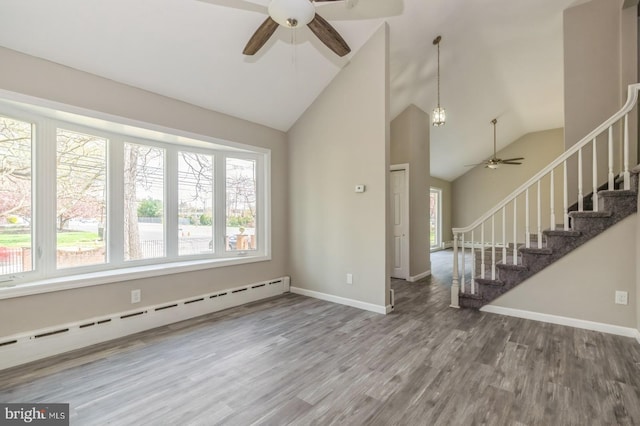 unfurnished living room featuring stairway, wood finished floors, baseboards, a baseboard radiator, and ceiling fan