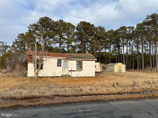 view of side of property with a storage shed and an outdoor structure