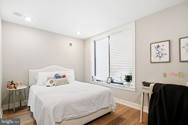 bedroom with visible vents, recessed lighting, baseboards, and wood finished floors