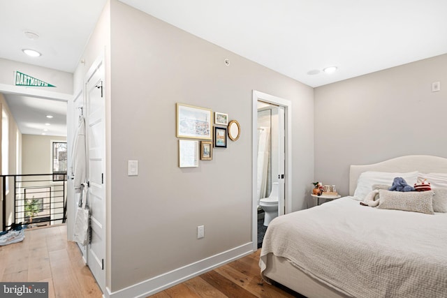 bedroom featuring light wood-style flooring, recessed lighting, baseboards, and connected bathroom