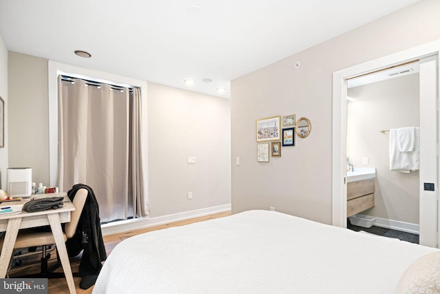 bedroom with wood finished floors, visible vents, and baseboards